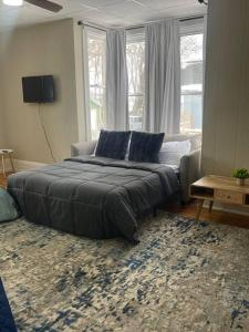 a bedroom with a bed and a couch and windows at Fancy Homes Manistee B with Lake View! in Manistee