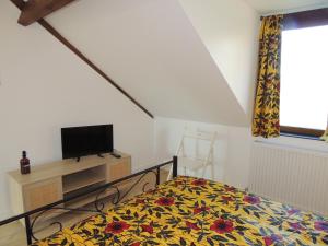 a bedroom with a bed and a tv and a window at LA VILLA QUI A DU CHIEN in Neuville-sur-Touques