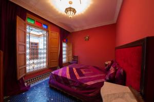 a bedroom with red walls and a bed and a window at Riad Scalia Traditional Guesthouse Fes Morocco in Fès