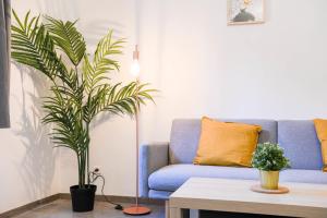 - un canapé bleu dans un salon avec une plante dans l'établissement Vieux-Port Grand appartement 2 ch avec terrasse, à Marseille