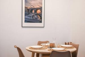 une salle à manger avec une table et une photo sur le mur dans l'établissement Appartement 1 ch à 1 min de la plage des Catalans, à Marseille