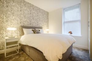 a bedroom with a large bed and a window at Flat 2, The Old Antiques Warehouse - FREE off-site Health Club access with Pool, Sauna, Steam Room & Gym in Bowness-on-Windermere