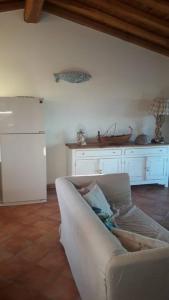 a living room with a white couch and a kitchen at Sunny House a Punta Molara in San Teodoro