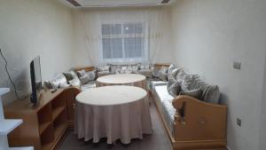 - un salon avec des canapés, des tables et une télévision dans l'établissement appartement NADOR wifi gratuit, à Nador