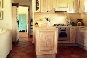 a kitchen with wooden cabinets and a stove at Sunny House a Punta Molara in San Teodoro