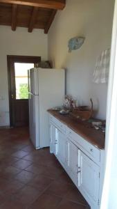 a kitchen with a white refrigerator and a tile floor at Sunny House a Punta Molara in San Teodoro