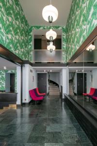a lobby with red chairs and green walls at Hôtel Pax in Geneva