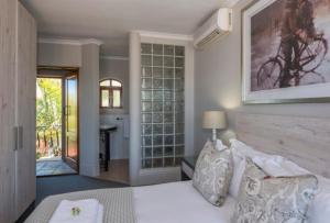 a bedroom with a bed and a room with a desk at Villa Tuscana in Port Elizabeth