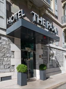 a hotel with a sign on the front of a building at Hôtel Pax in Geneva