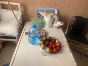 a table with a bunch of fruit and a bottle of water at Appartement, tilila in Mirleft +21 photos