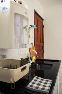 uma cozinha com um lavatório e uma bancada em CASA NA RUA DO PIRUÍ EM AREMBEPE com ar em Arembepe