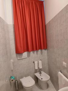 y baño con aseo y cortina de ducha roja. en Alloggio Al Ponte en Castelgomberto