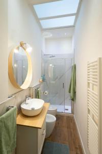 ein Bad mit einem Waschbecken, einem Spiegel und einer Dusche in der Unterkunft B&B Porta 93 in Pistoia