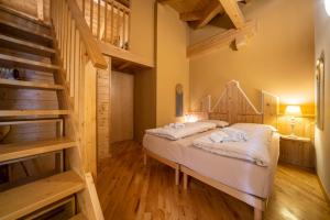 Schlafzimmer mit einem Bett und Holzböden in der Unterkunft Ciasa Gianot - Shin in Moena