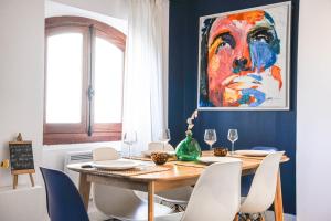 a dining room with a table with chairs and a painting at Grand appartement 2 chambres avec vue Vieux-Port in Marseille
