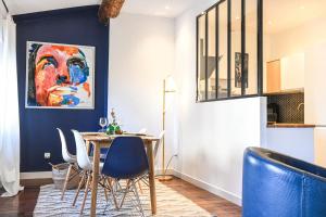 マルセイユにあるGrand appartement 2 chambres avec vue Vieux-Portのダイニングルーム(テーブル、青い椅子付)