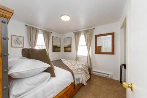 Un dormitorio con una cama con almohadas blancas y una ventana en Adorable 2 BD 1 BTH Home Minutes Away from Gonzaga, en Spokane