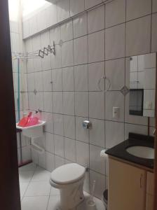 ein Bad mit einem WC und einem Waschbecken in der Unterkunft Residencial Andorinhas in Bombinhas