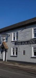un edificio con el cartel de la posada Fox. en The Fox Inn en Abingdon