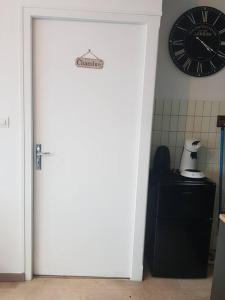 uma porta para uma cozinha com um relógio na parede em Magnifique T2 au centre ville em Cluses