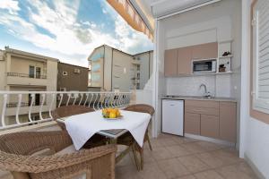 a kitchen with a table and chairs on a balcony at Villa Fina in Tučepi