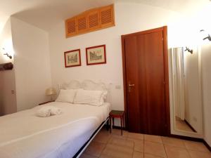 ein Schlafzimmer mit einem weißen Bett und einer Holztür in der Unterkunft Colosseo Home - 29061 in Rom