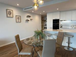 a kitchen and dining room with a glass table and chairs at Deluxe Bay View in Câmara de Lobos