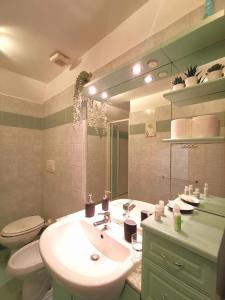 ein Badezimmer mit einem Waschbecken, einem WC und einem Spiegel in der Unterkunft Colosseo Home - 29061 in Rom