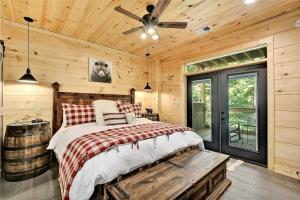 - une chambre avec un lit et un ventilateur de plafond dans l'établissement Oakley's Mountain Modern Lodge - Luxury Family Cabin in Arts and Craft District, à Gatlinburg