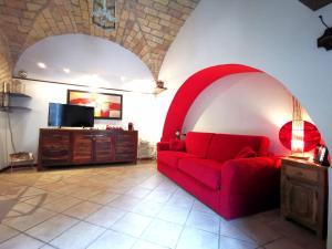 ein Wohnzimmer mit einem roten Sofa und einem TV in der Unterkunft Colosseo Home - 29061 in Rom