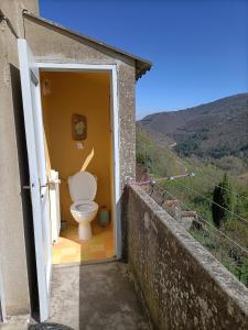 ein Bad mit einem WC in einer offenen Tür in der Unterkunft Gîte Miss Cardabelle in La Bastide-Pradines