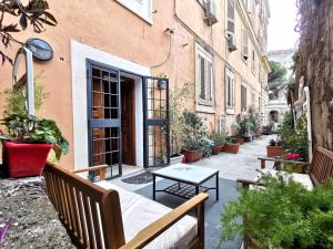 eine Terrasse mit einem Tisch und Bänken vor einem Gebäude in der Unterkunft Colosseo Home - 29061 in Rom