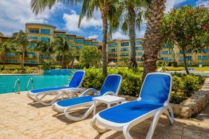 a group of chairs and a pool at a resort at 2Bdr Ground Floor Condo With Terrrace! in Palm-Eagle Beach