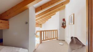 a bedroom with white walls and wooden beams at Abitaziun Cravunera - Sils Maria in Sils Maria
