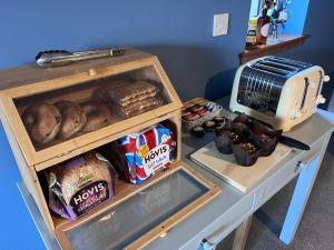 einen Tisch mit einer Theke mit Brot und einem Toaster in der Unterkunft Balachladaich Loch Ness B&B in Dores