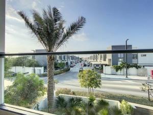 a view of a palm tree from a balcony at Key View - Villa Gardenia Jebel Ali in Dubai