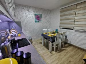 eine Küche mit einem Tisch, einem Tisch und Stühlen in der Unterkunft Midori Zlatar in Nova Varoš