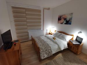 una camera da letto con un letto e una scrivania con un computer portatile di Midori Zlatar a Nova Varoš