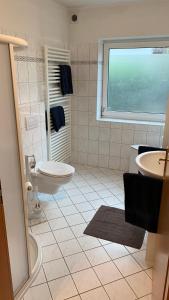 ein Bad mit einem Waschbecken, einem WC und einem Fenster in der Unterkunft Apartment close to the center + free parking in Oldenburg
