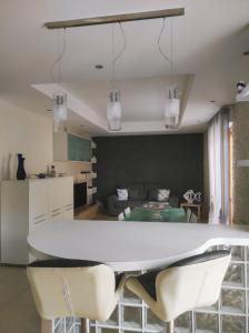eine Küche und ein Wohnzimmer mit einem weißen Tisch und Stühlen in der Unterkunft Casa Cortese in Gallipoli