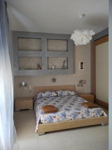 ein Schlafzimmer mit einem Bett mit blau-weißer Bettwäsche in der Unterkunft Casa Cortese in Gallipoli