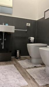 a bathroom with a sink and a toilet and rugs at Rodinó rooms in Naples