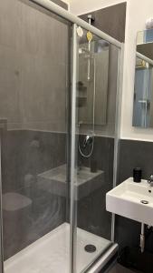 a shower with a glass door next to a sink at Rodinó rooms in Naples