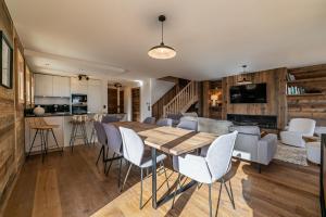 cocina y sala de estar con mesa de madera y sillas en Duplex Pen Men : un bien d'exception avec jacuzzi !, en Les Gets