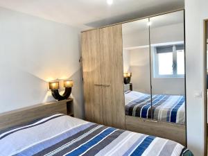 Dormitorio con armario con espejo y cama en Appartement Léonard, comme à la maison - Vieux Lille en Lille