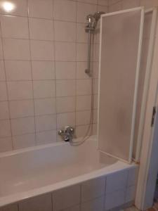 a bathroom with a white tub and a shower at Wohnung Rheintal im Alpenvorland in Batschuns