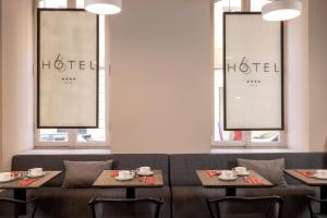 a restaurant with two tables and chairs and two windows at Hotel 66 Nice in Nice