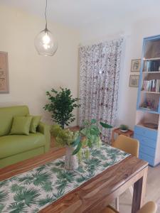 sala de estar con mesa y sofá verde en CASA NELLA Appartamento nel Centro Storico, en Gambassi Terme