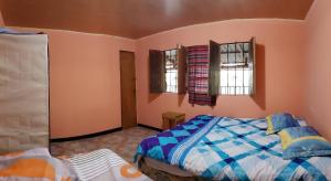 ein Schlafzimmer mit einem Bett und zwei Fenstern in der Unterkunft Brisas de San Ignacio in San Ignacio