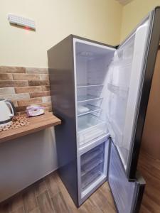 an empty refrigerator with its door open in a kitchen at Serafi Cozy Rooms in Archangelos